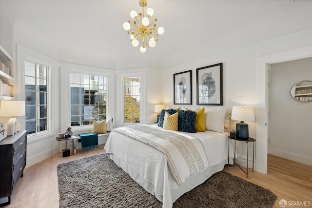 bedroom with hardwood / wood-style floors and an inviting chandelier