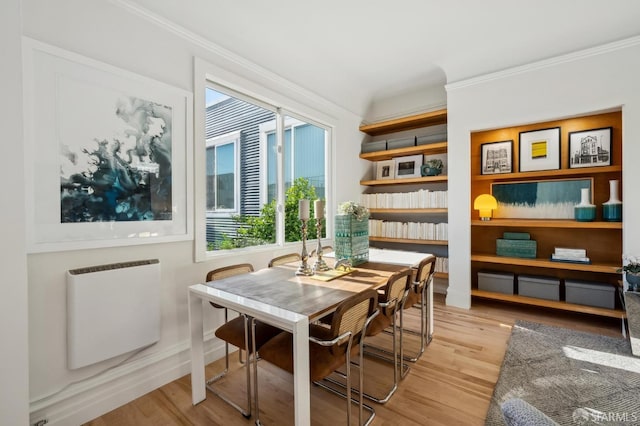 living area featuring ornamental molding, radiator, and light hardwood / wood-style flooring