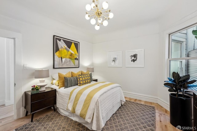 bedroom with a chandelier and wood-type flooring