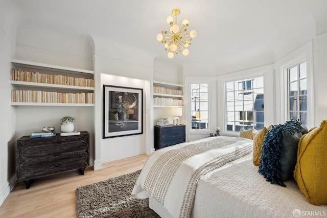 bedroom featuring light hardwood / wood-style flooring and a notable chandelier