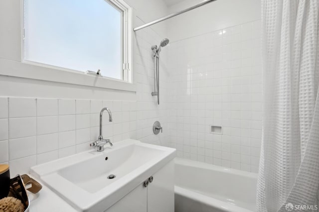 bathroom with shower / bath combination with curtain, tile walls, sink, and tasteful backsplash