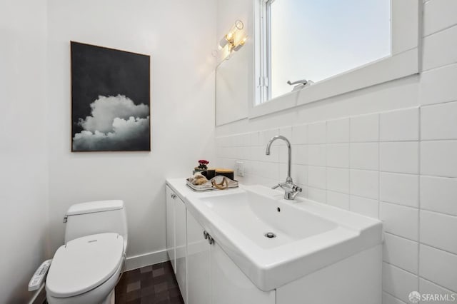 bathroom with vanity, tasteful backsplash, and toilet