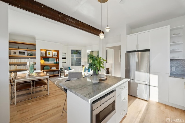 kitchen with a center island, white cabinetry, stainless steel appliances, and hanging light fixtures