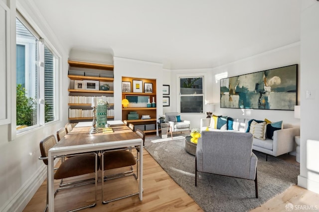 living room featuring plenty of natural light, crown molding, and light hardwood / wood-style flooring