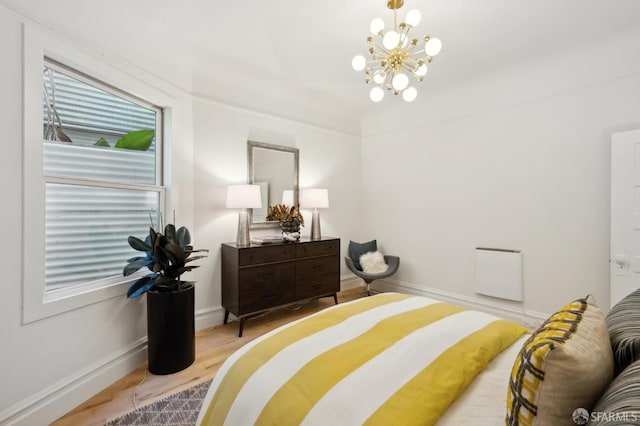 bedroom featuring a chandelier and light hardwood / wood-style floors