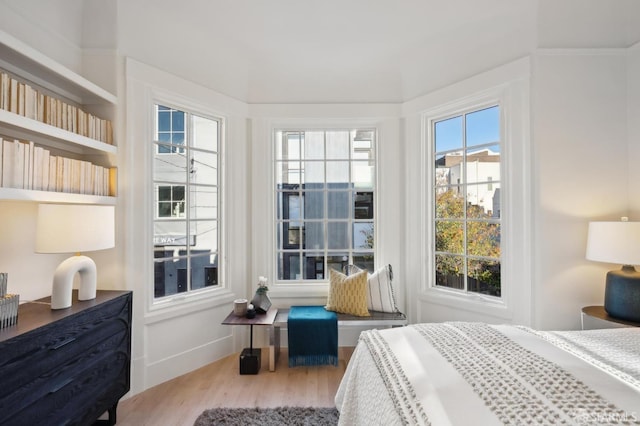 bedroom with wood-type flooring and multiple windows