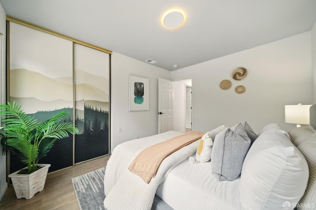 bedroom featuring a closet, wood finished floors, and visible vents