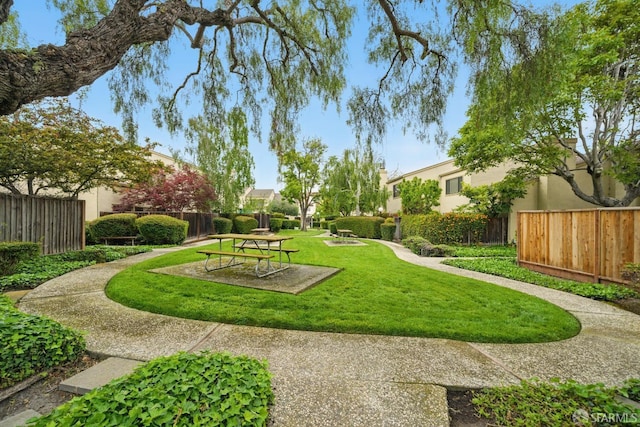 surrounding community with a lawn and fence