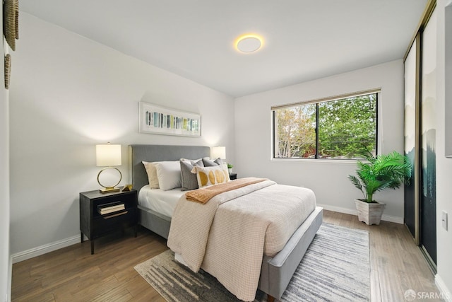 bedroom featuring baseboards and wood finished floors