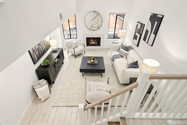 living area featuring a lit fireplace and wood finished floors
