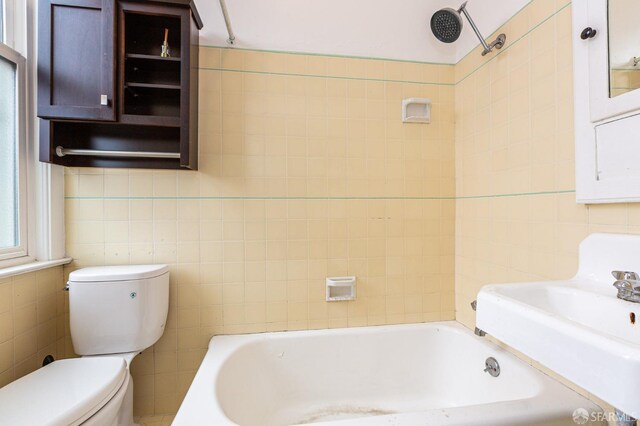 full bathroom featuring tile walls, toilet, sink, and tiled shower / bath