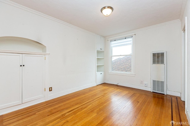 unfurnished room with hardwood / wood-style flooring and ornamental molding