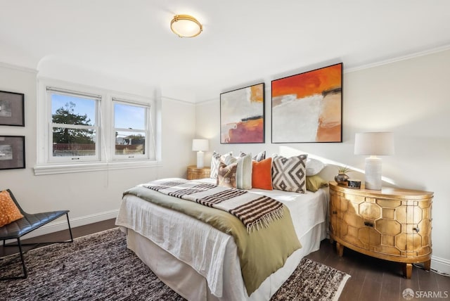 bedroom featuring ornamental molding, baseboards, and wood finished floors