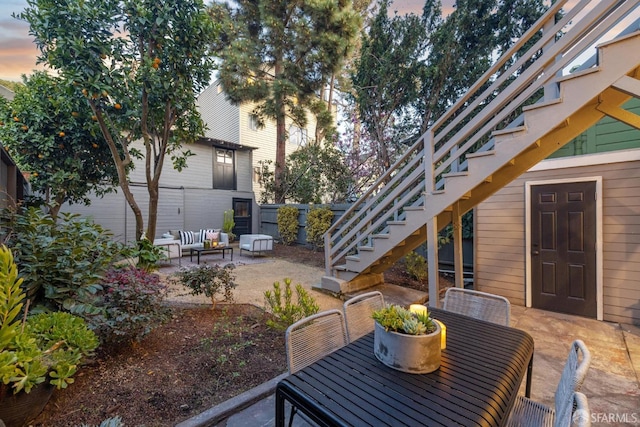 view of patio with outdoor dining area, stairway, and fence