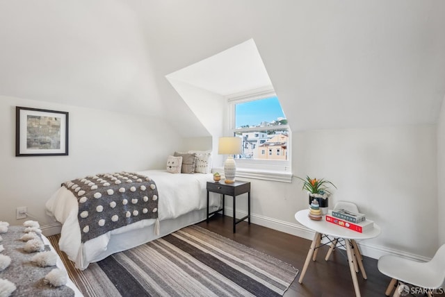 bedroom with lofted ceiling, baseboards, and wood finished floors