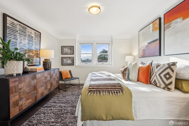 bedroom featuring baseboards, ornamental molding, and wood finished floors