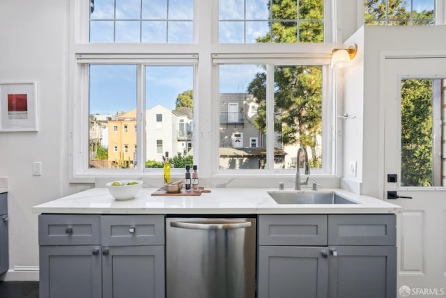 interior space with stainless steel dishwasher, a sink, and a wealth of natural light