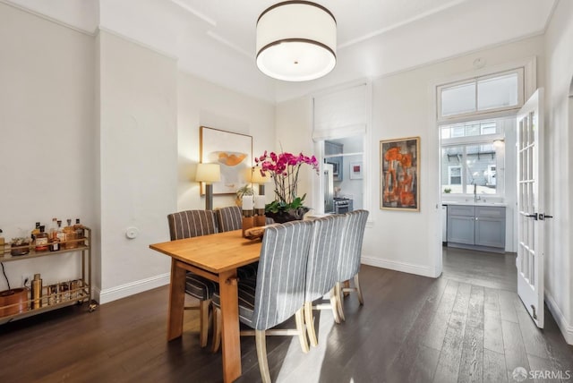 dining space with dark wood-type flooring and baseboards