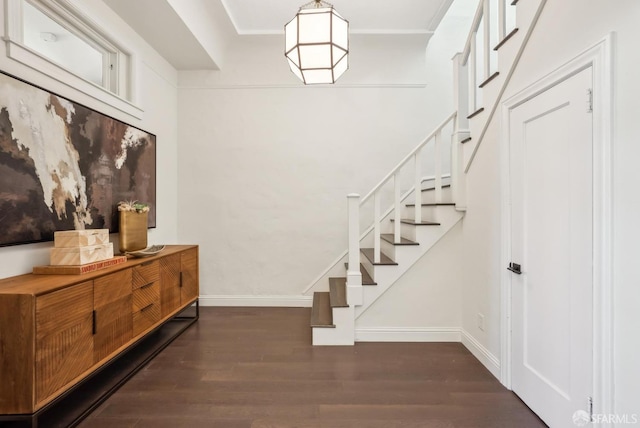 entryway with stairs, baseboards, and wood finished floors