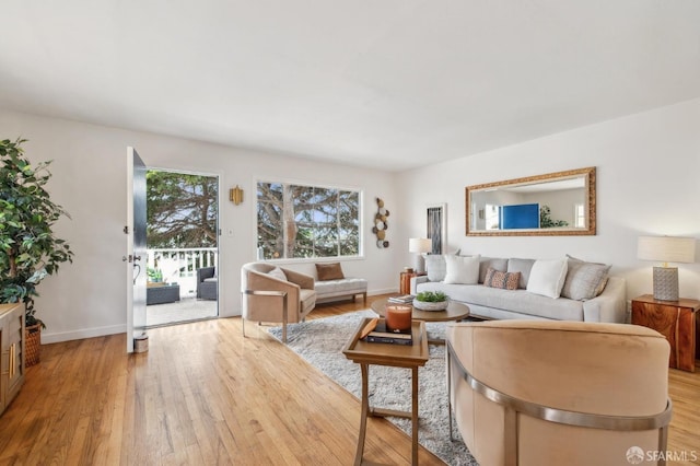 living area with baseboards and light wood finished floors