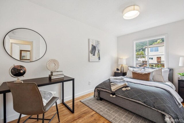 bedroom featuring light wood-style floors and baseboards