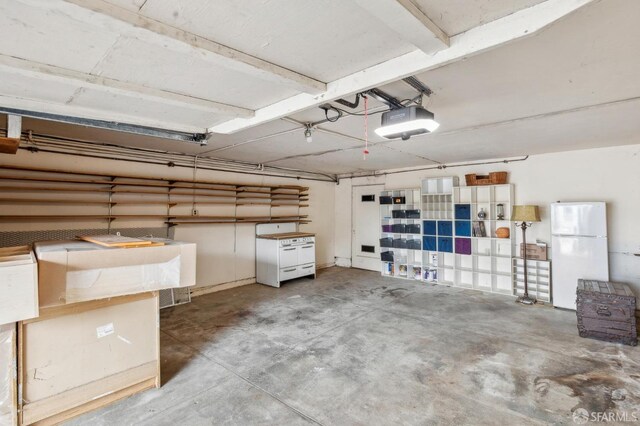 garage with a garage door opener and freestanding refrigerator