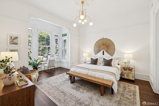 bedroom with an inviting chandelier and dark wood-type flooring