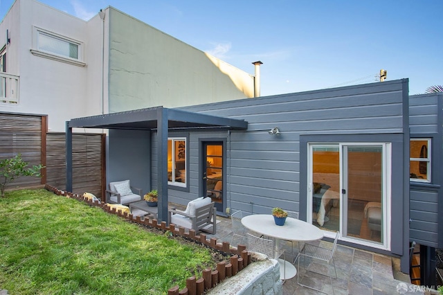 rear view of property featuring a patio and a lawn