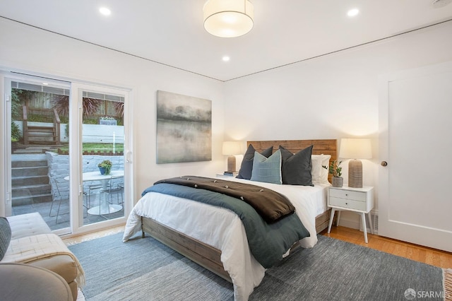 bedroom with wood-type flooring and access to exterior