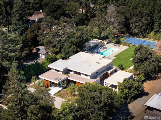 drone / aerial view of a heavily wooded area and a pool