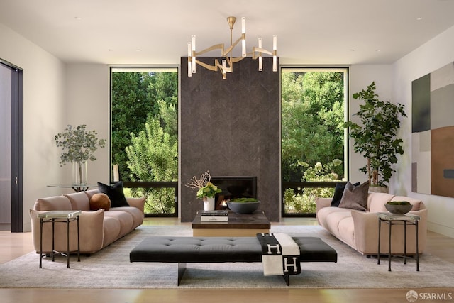 sitting room featuring floor to ceiling windows, a chandelier, healthy amount of natural light, wood finished floors, and a fireplace