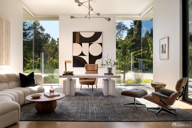 living area with expansive windows, a chandelier, and hardwood / wood-style floors