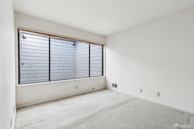 unfurnished room featuring light carpet