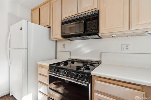 kitchen featuring light brown cabinetry and black appliances