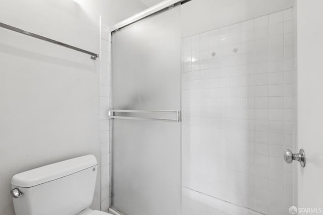 bathroom featuring an enclosed shower and toilet