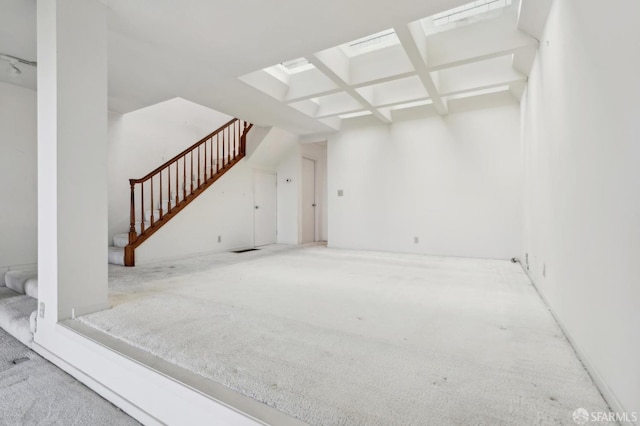 unfurnished living room with coffered ceiling and beamed ceiling