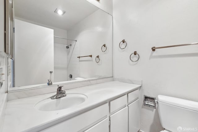 full bathroom featuring vanity, tiled shower / bath combo, and toilet