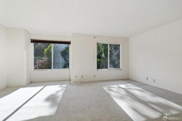 spare room with plenty of natural light and light colored carpet