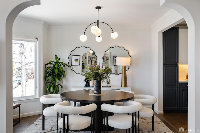1347 Green St, San Francisco, CA 94109 - dining room with arched walkways, dark wood finished floors, baseboards, crown molding, and a chandelier