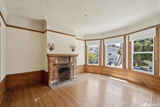 570 Jersey St, San Francisco, CA 94114 - unfurnished living room featuring a textured ceiling, wood finished floors, a fireplace, a wainscoted wall, and crown molding
