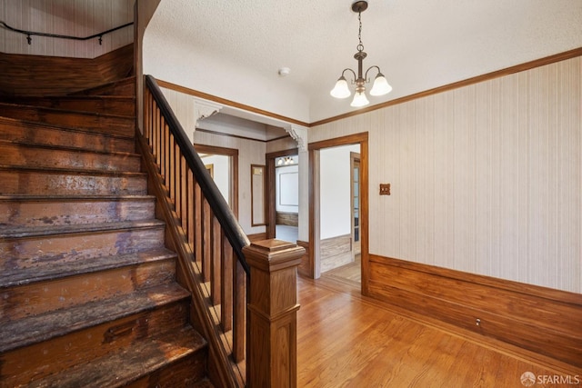 570 Jersey St, San Francisco, CA 94114 - staircase with a chandelier, wood finished floors, and crown molding