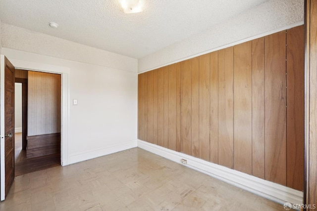 570 Jersey St, San Francisco, CA 94114 - spare room featuring tile patterned floors, wooden walls, a textured ceiling, and a smoke detector