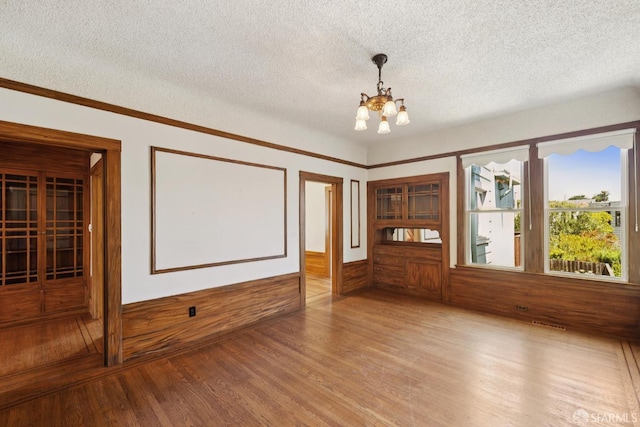 570 Jersey St, San Francisco, CA 94114 - unfurnished room featuring a chandelier, a textured ceiling, wood finished floors, wainscoting, and wood walls