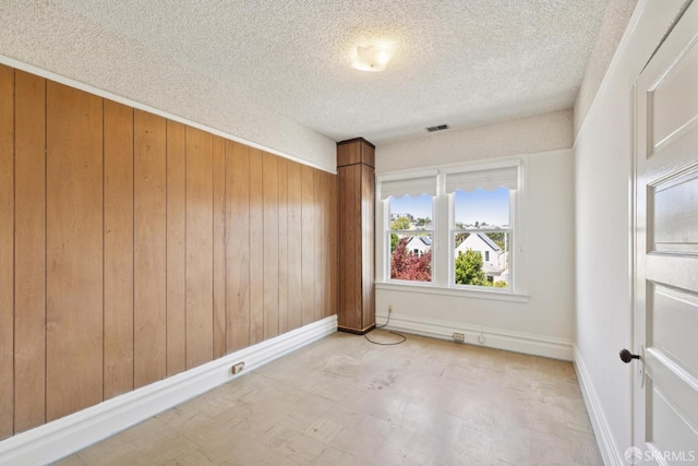 570 Jersey St, San Francisco, CA 94114 - spare room featuring wood walls, a textured ceiling, and tile patterned floors