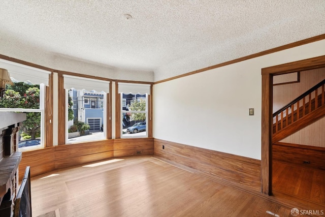 570 Jersey St, San Francisco, CA 94114 - unfurnished room featuring wood finished floors, a textured ceiling, wooden walls, ornamental molding, and a wainscoted wall