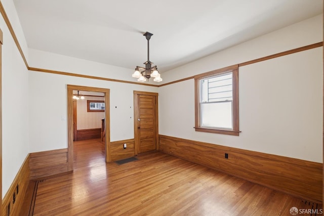 570 Jersey St, San Francisco, CA 94114 - empty room with a chandelier, a wainscoted wall, light wood-style flooring, and wood walls