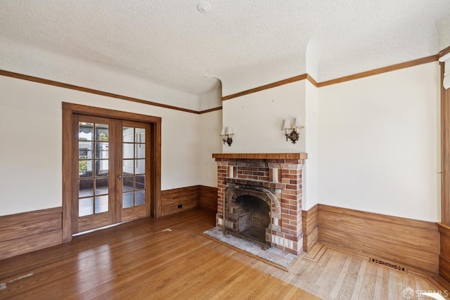 570 Jersey St, San Francisco, CA 94114 - unfurnished living room with wainscoting, wood finished floors, a textured ceiling, wooden walls, and a fireplace