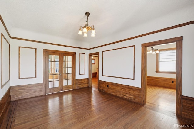 570 Jersey St, San Francisco, CA 94114 - spare room with a chandelier, wood finished floors, a wainscoted wall, french doors, and wooden walls