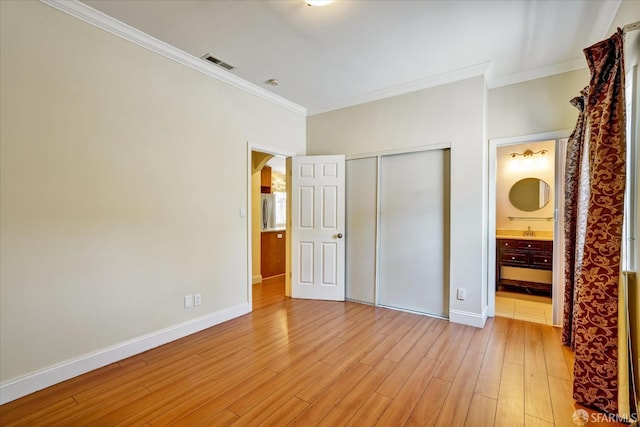 2486 26th Ave, Oakland, CA 94601 - unfurnished bedroom with ornamental molding, light wood finished floors, a closet, arched walkways, and ensuite bath