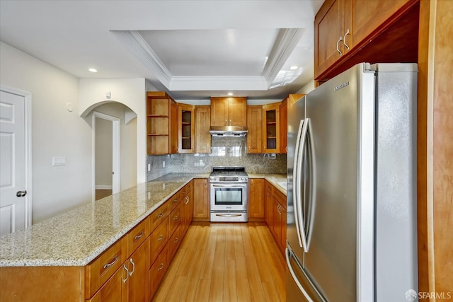 2486 26th Ave, Oakland, CA 94601 - kitchen with appliances with stainless steel finishes, a peninsula, under cabinet range hood, a raised ceiling, and brown cabinets